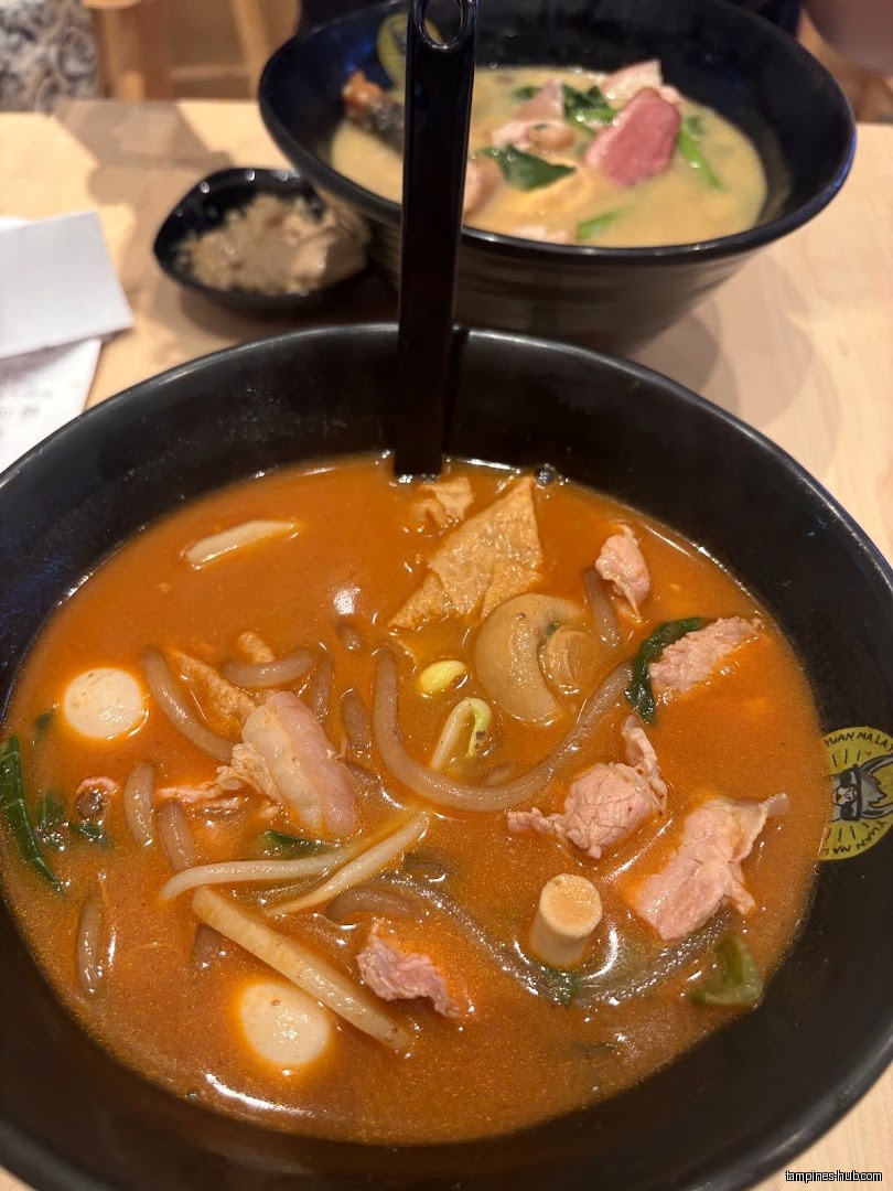Two bowls of Mala Tang soup with meat and vegetables are shown.