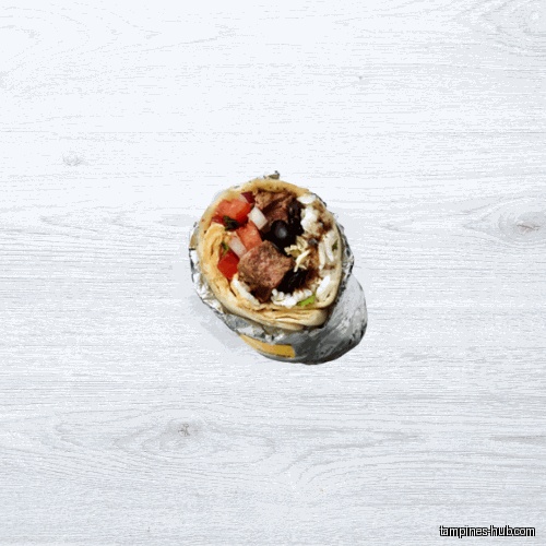 A close-up shot of a burrito wrapped in foil on a white surface.