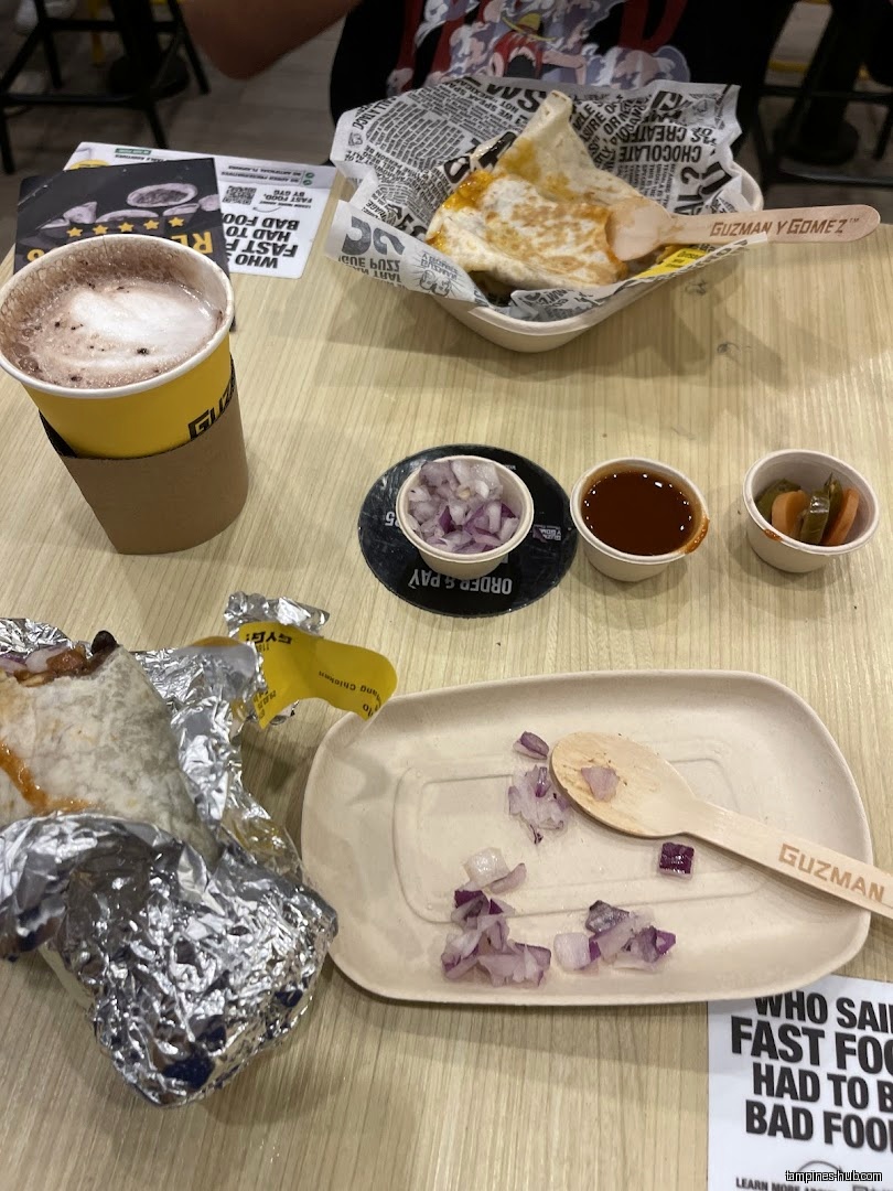 A table with Guzman y Gomez food, including a quesadilla and burrito.