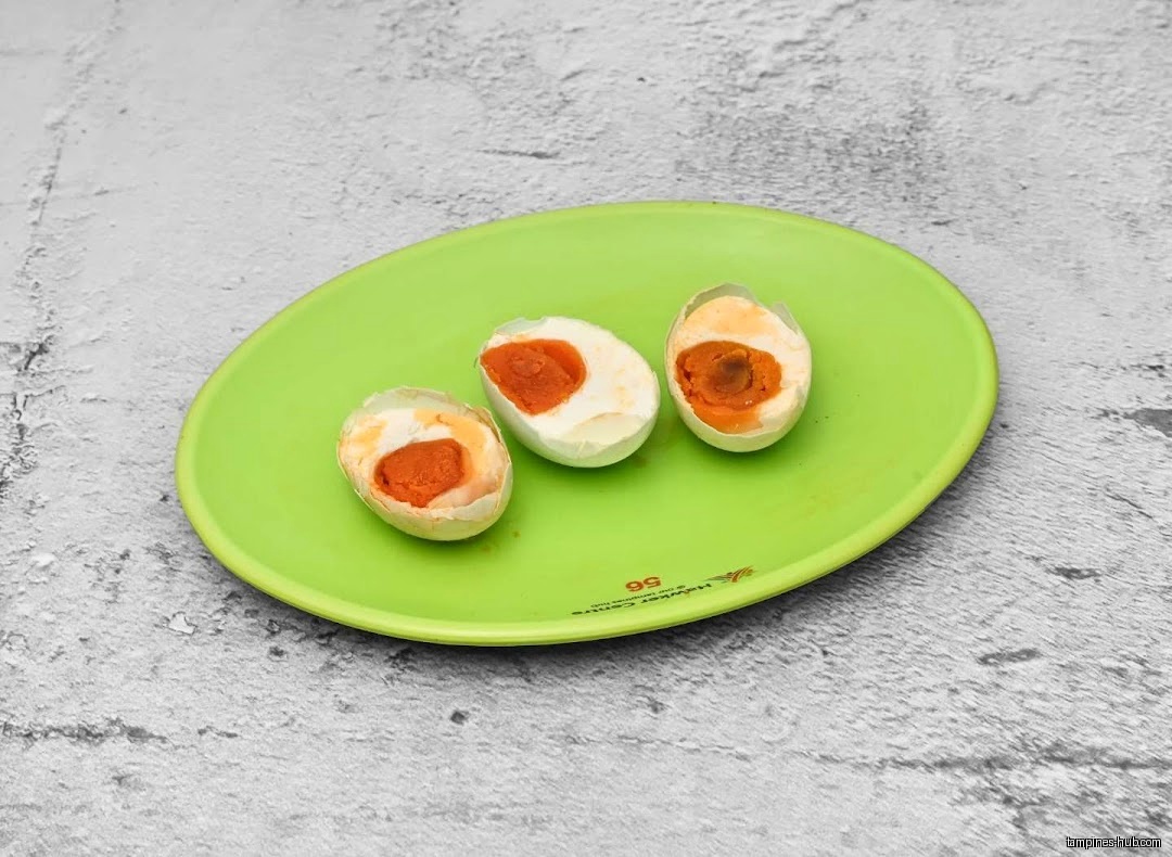Three halved salted eggs are displayed on a green plate.
