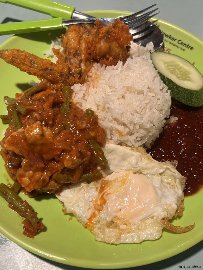 A plate of Nasi Lemak with fried chicken, egg, and sambal.