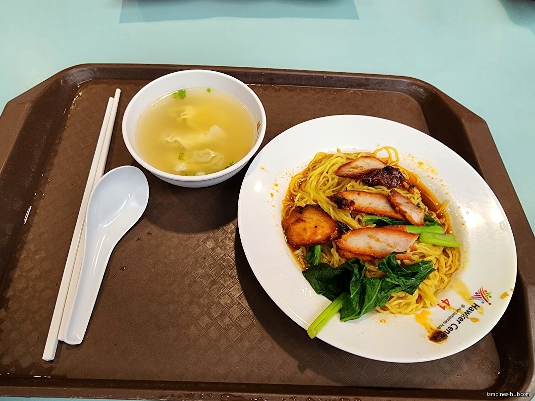 A tray with a plate of noodles, soup, chopsticks, and a spoon.