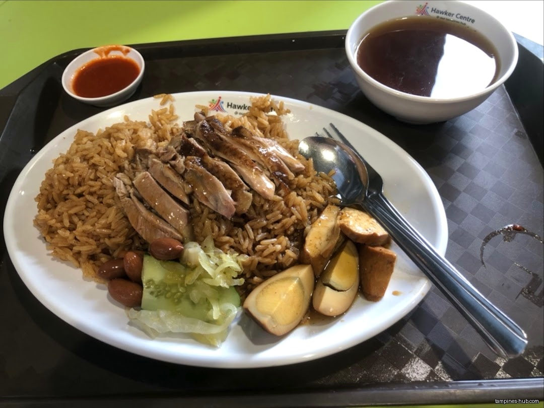 A plate of duck rice with sides and soup on a tray.