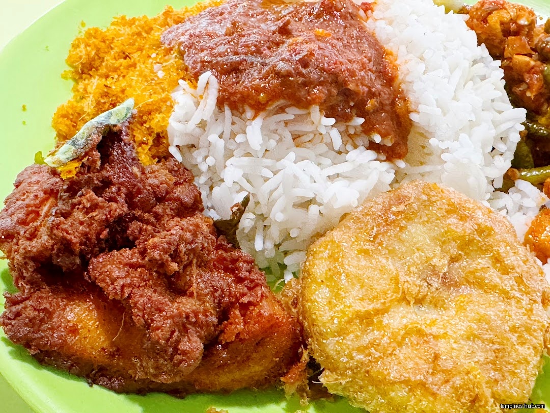 A plate of nasi lemak with fried chicken, egg, and sambal.