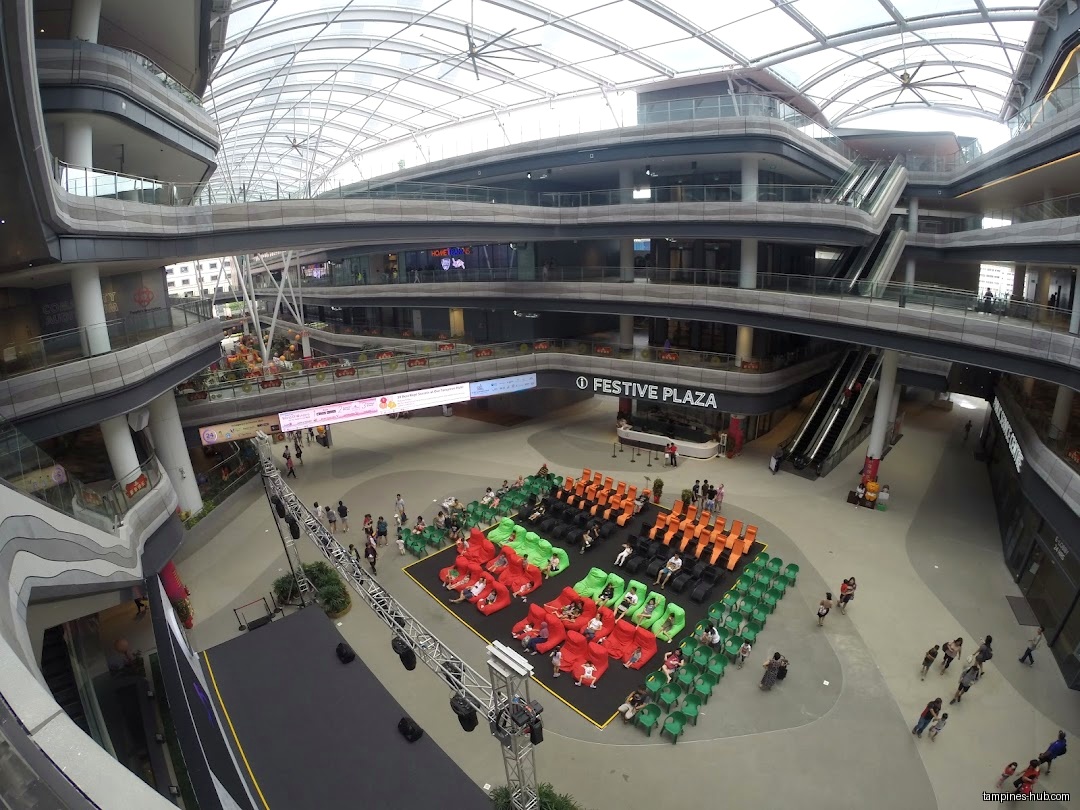 A multi-level shopping mall with an event space and seating.