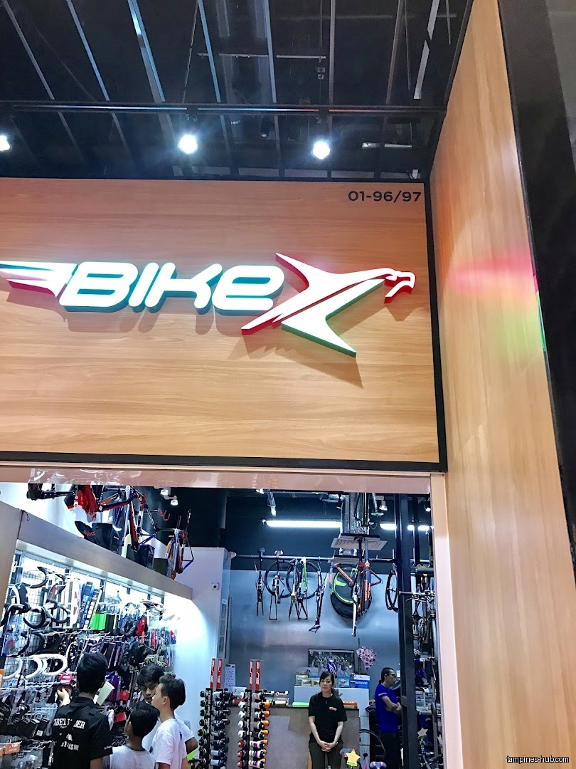 The image shows the entrance to a bike shop with a large logo.