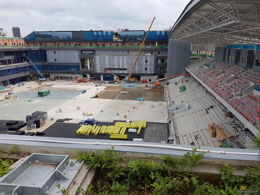 Construction site with a stadium, building, and workers visible.