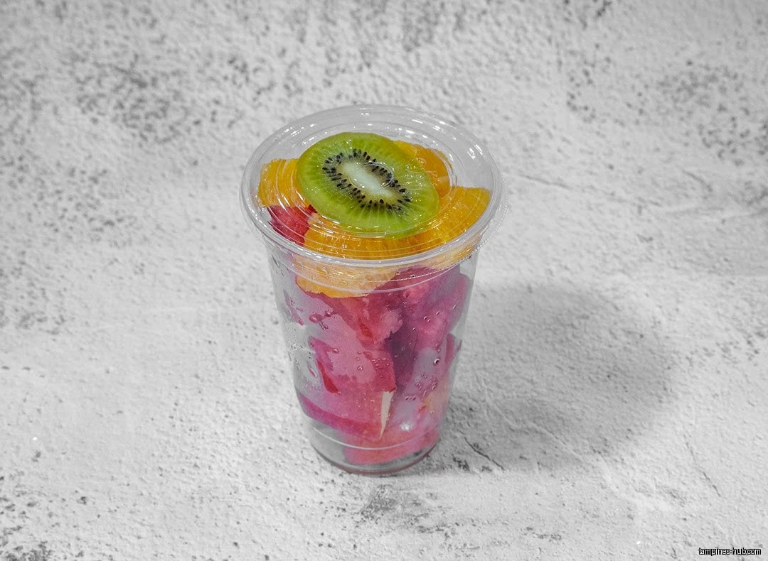 A clear plastic cup filled with cut fruit, including kiwi and watermelon.