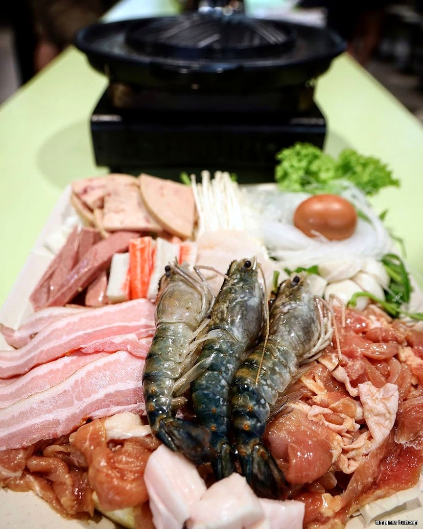A platter of raw meat, seafood, and vegetables for a hotpot meal.