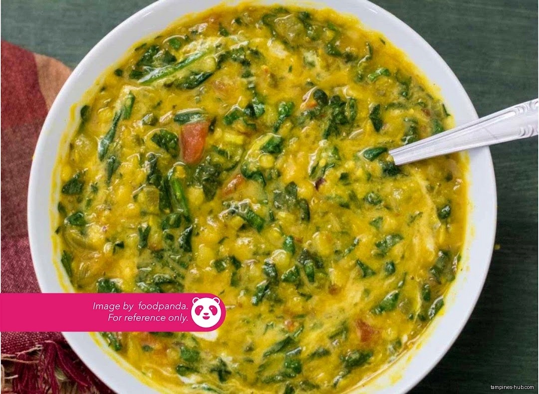 A bowl of Indian spinach dal with a spoon, from Foodpanda.