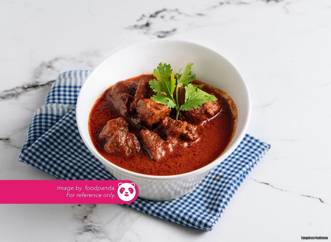 A bowl of Indian curry with meat and cilantro garnish is shown.
