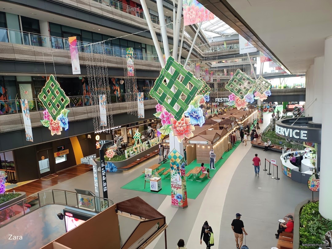 The image shows a shopping mall decorated for a festival with stalls.