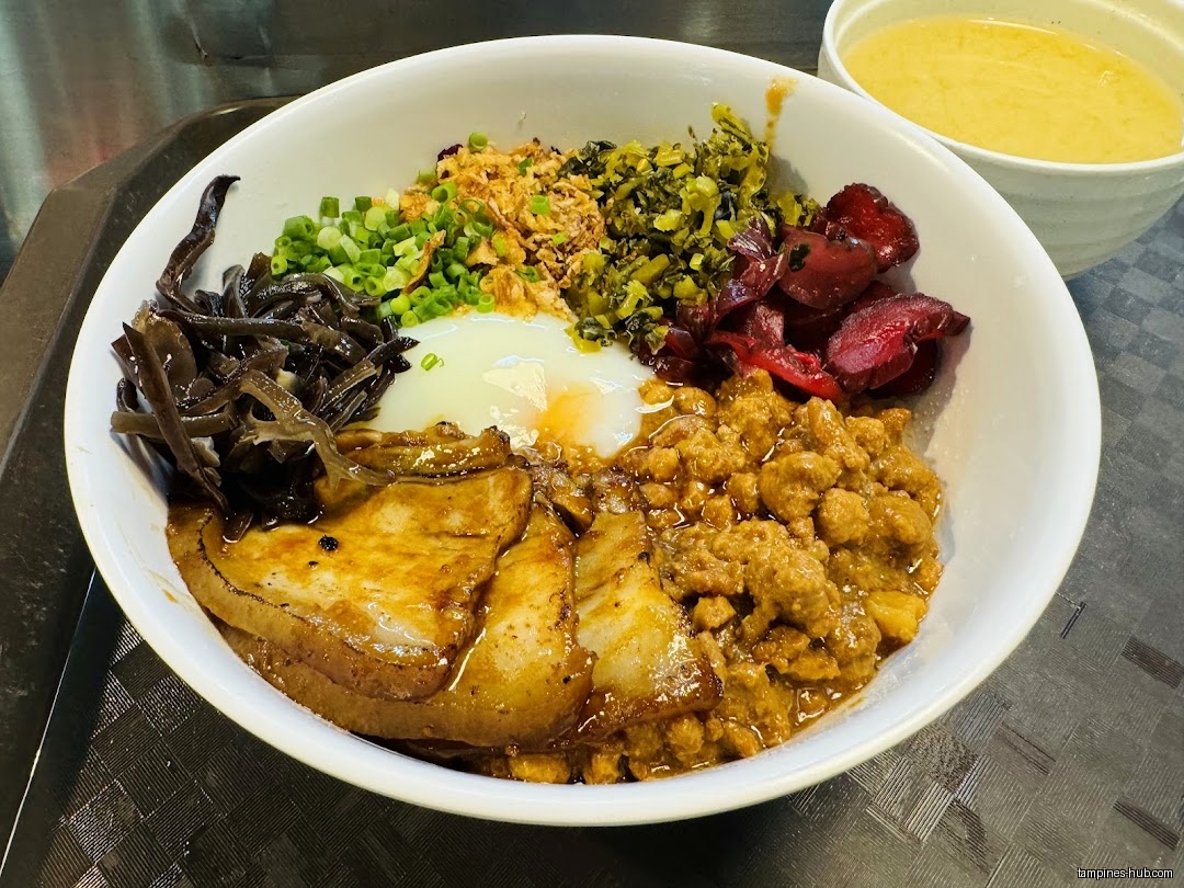 A bowl of IPPON Fusion Bowl food with various toppings and a soup.