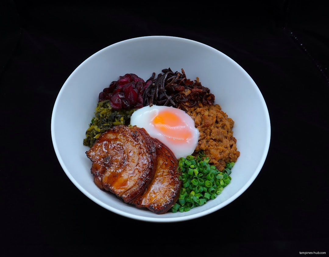 A white bowl filled with meat, vegetables, and a poached egg.