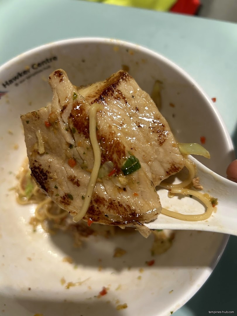 Close-up of grilled pork and noodles on a spoon, from IPPON Fusion Bowl.