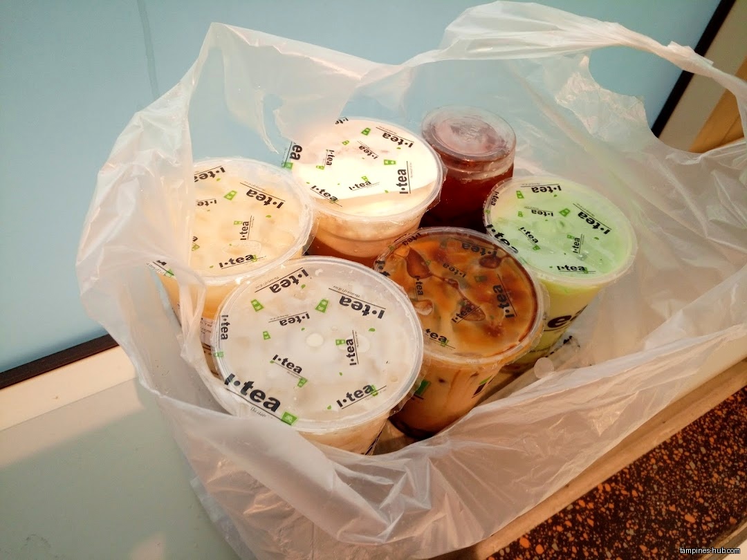 A plastic bag filled with several iTEA drinks in plastic cups.