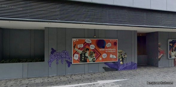 The image shows a wall with posters and graffiti art.