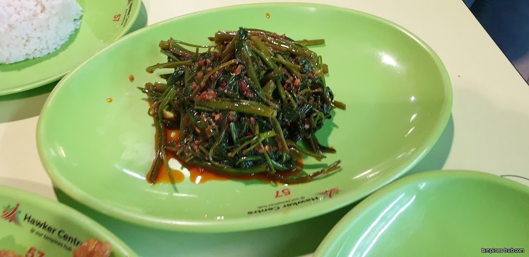 A plate of stir-fried water spinach (kangkong) with rice on green plates.