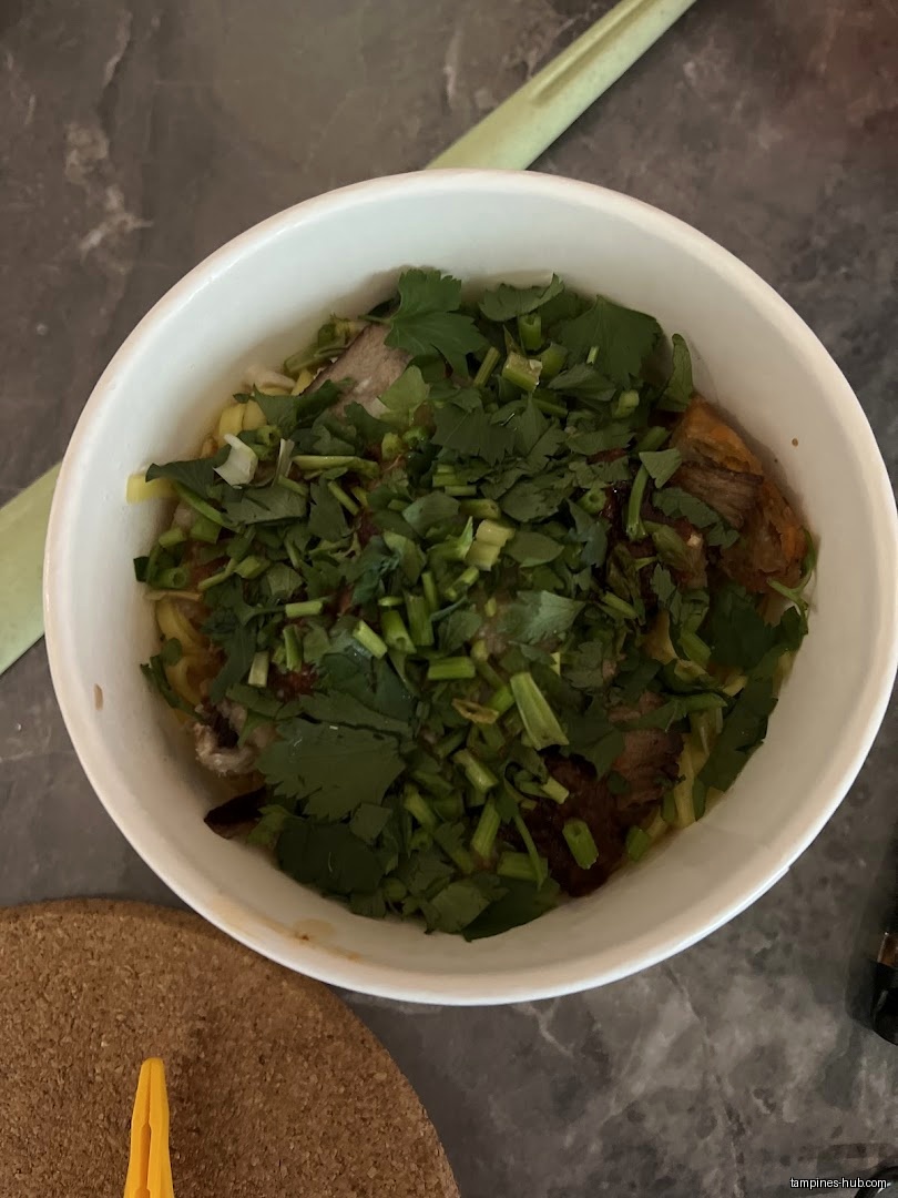 A bowl of Lor Mee with lots of green herbs on top.