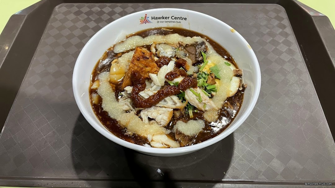 A bowl of Lor Mee on a tray, featuring various toppings.