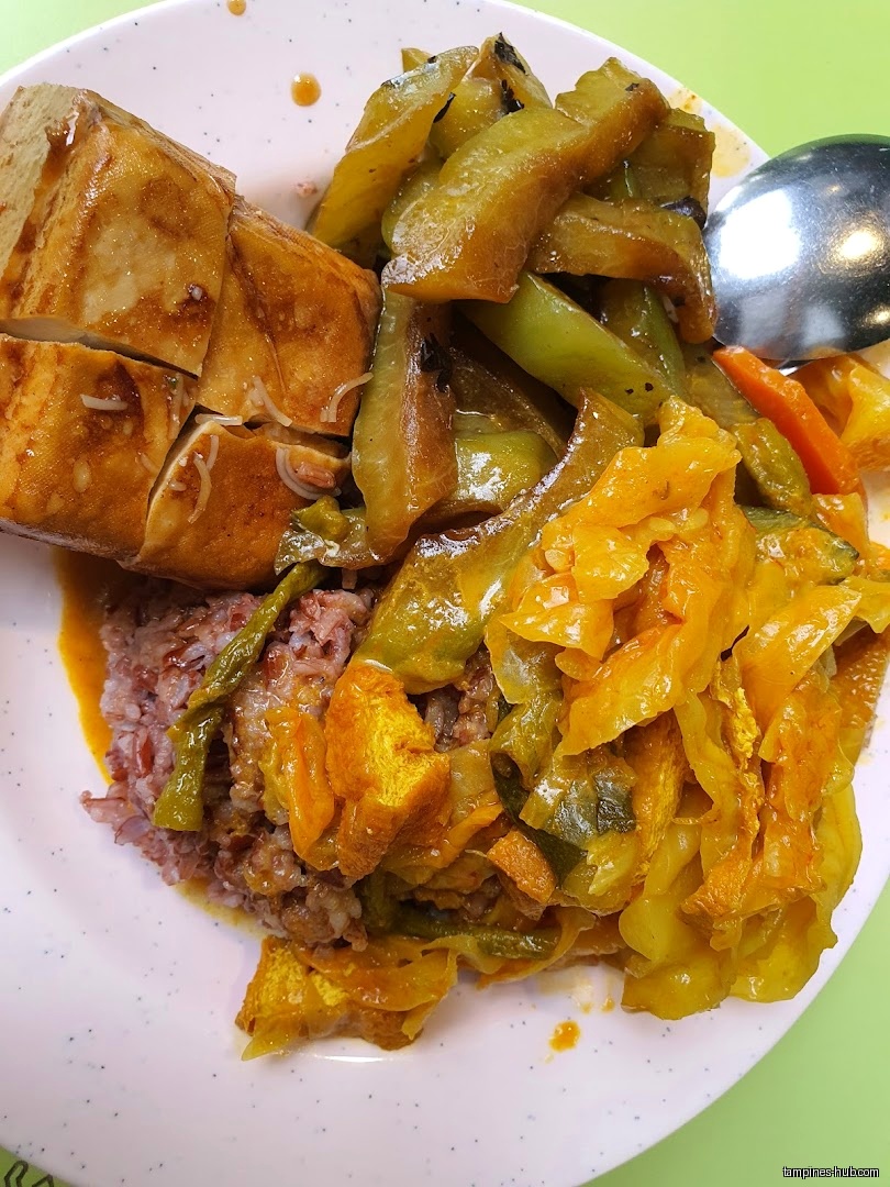 A plate of vegetarian food with tofu, rice, and stir-fried vegetables.