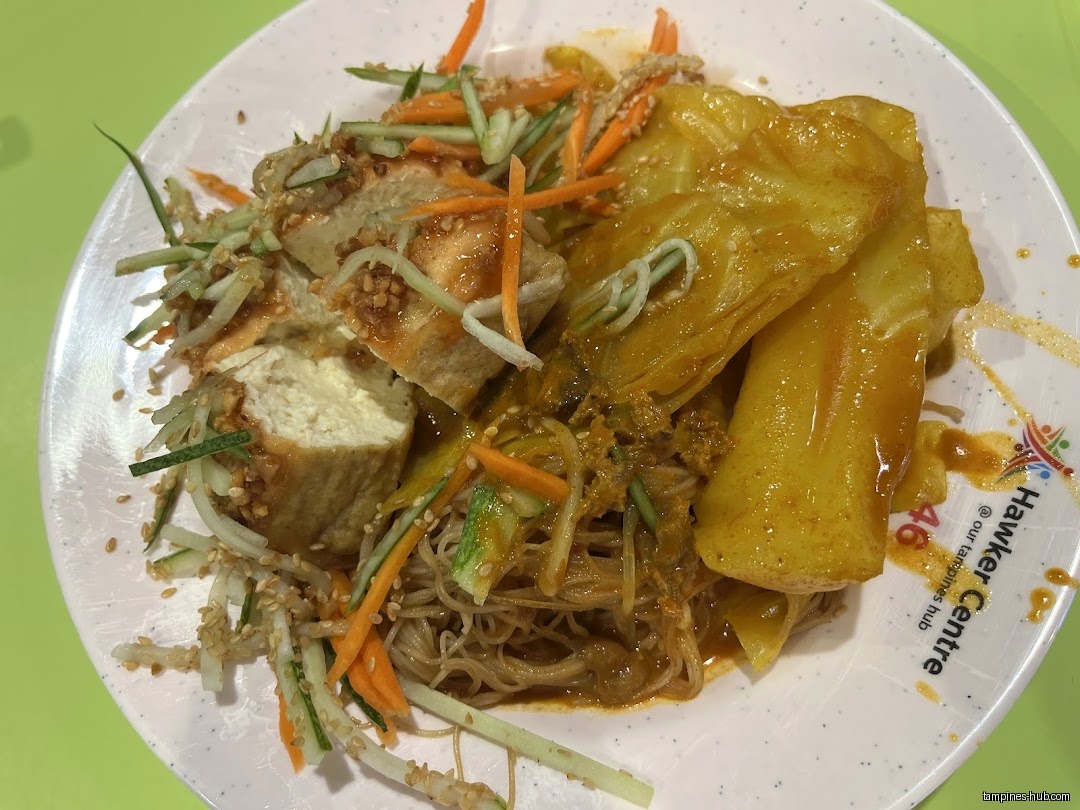 A plate of vegetarian food with tofu, noodles, and vegetables.