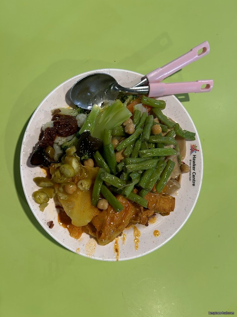 A plate of vegetarian food with green beans and other vegetables.