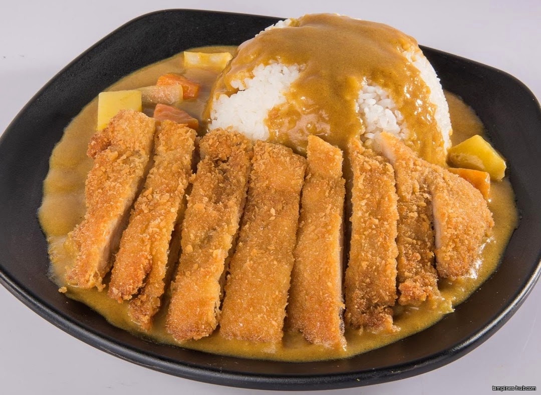 A plate of Japanese curry with rice and sliced fried cutlet.
