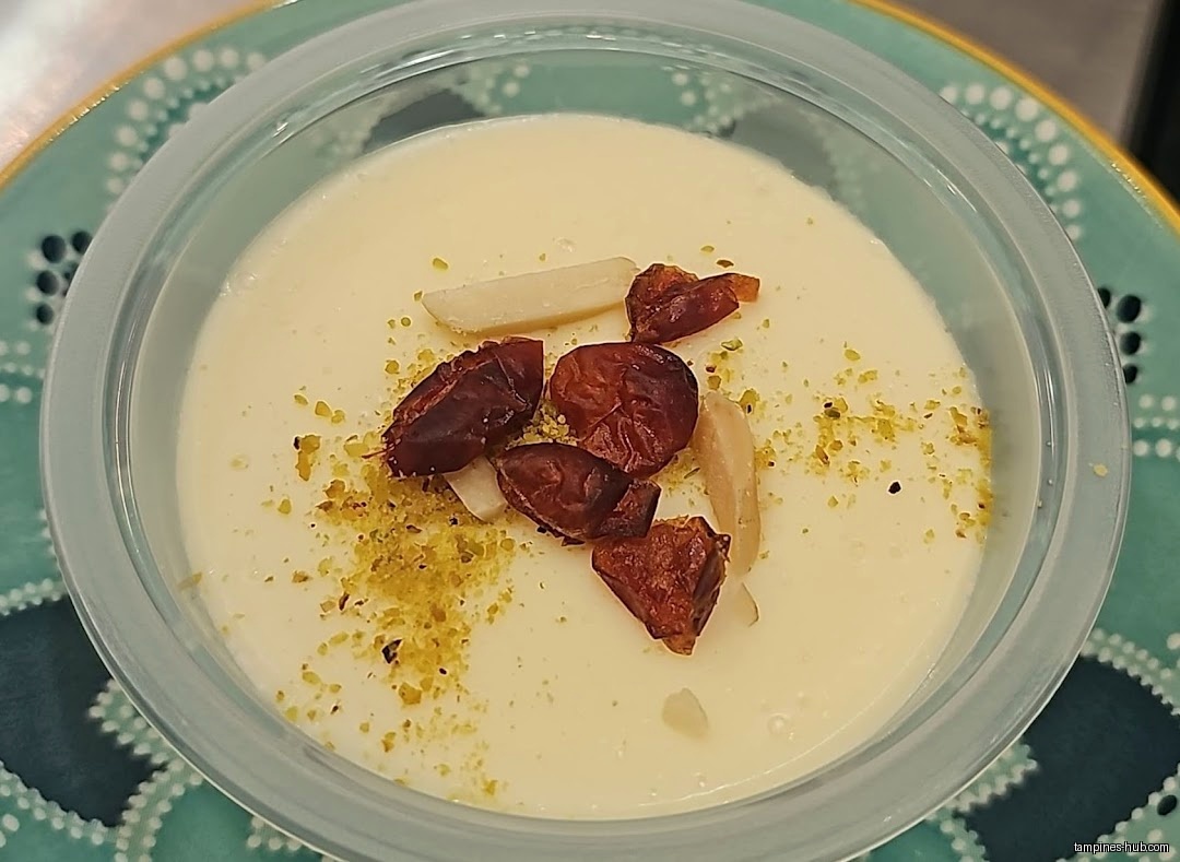 A close-up of a dessert with nuts and dates in a container.