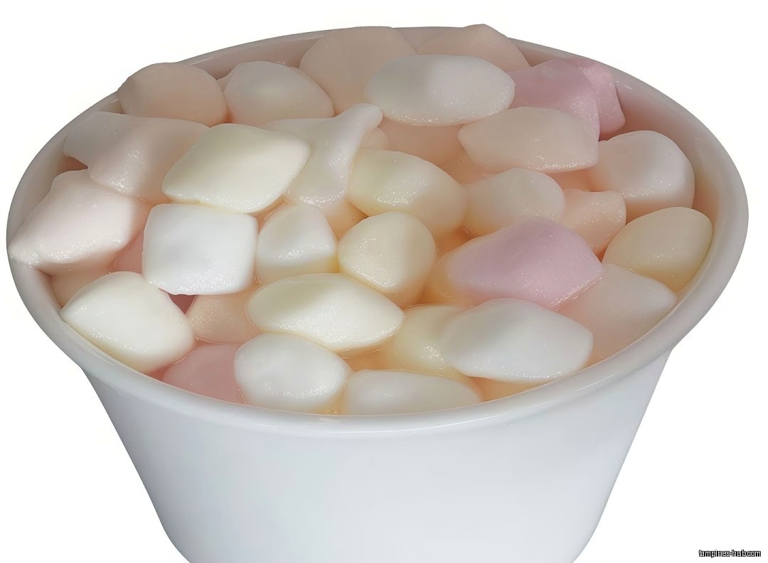 A white cup filled with small, colorful, pebble-shaped candies.
