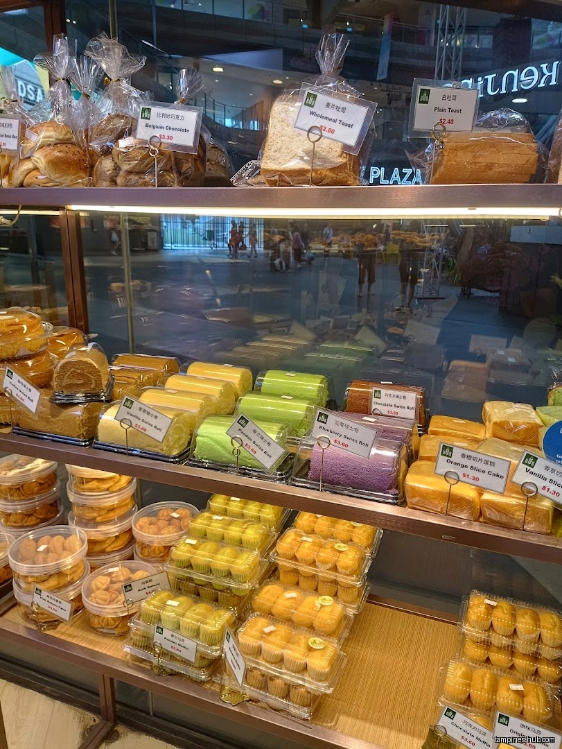 A display case at KenJinn Bakery filled with various breads and pastries.