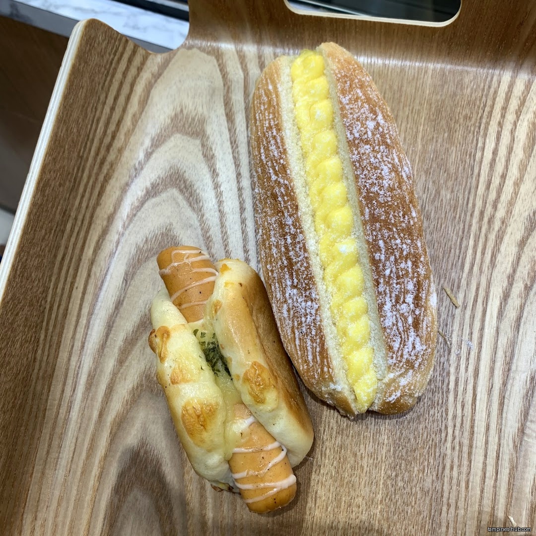 Two types of bread from KenJinn Bakery are displayed on a wooden tray.