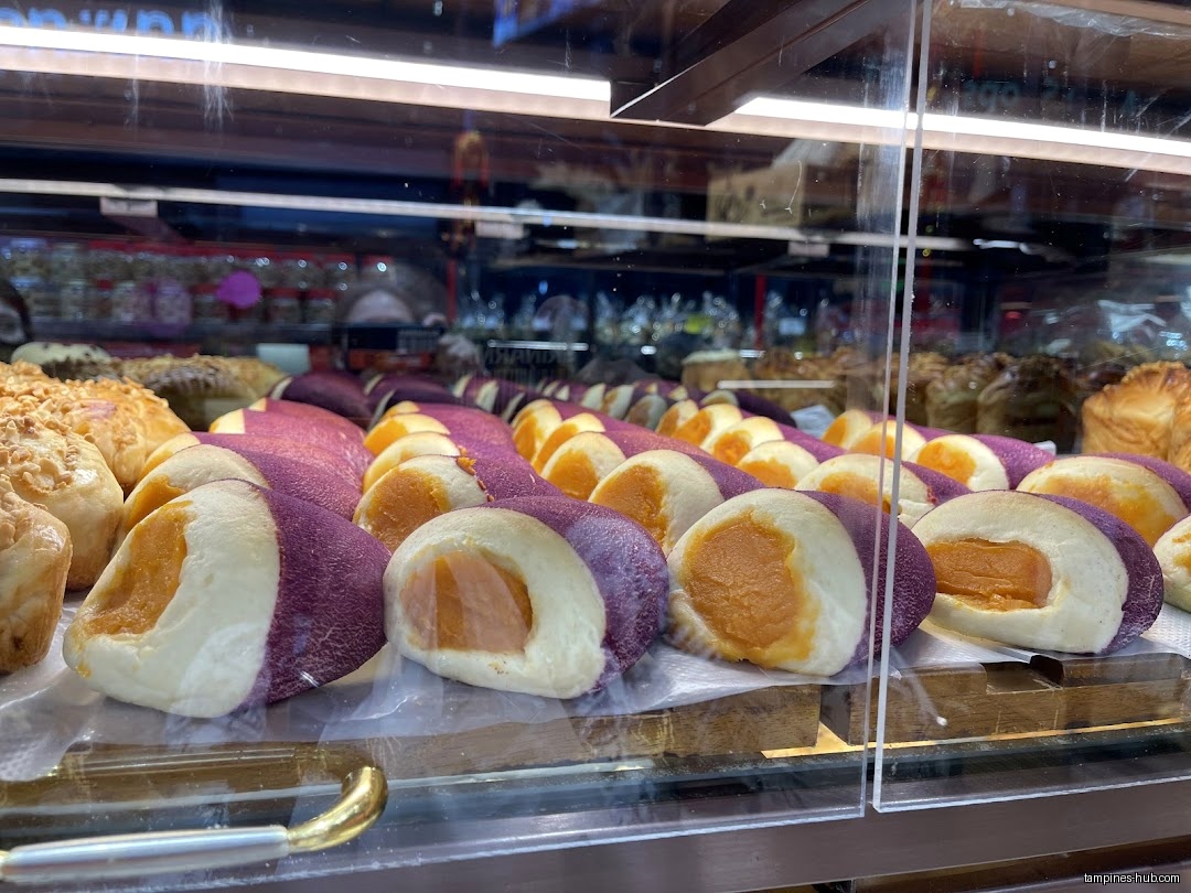 A display case filled with various baked goods at KenJinn Bakery.