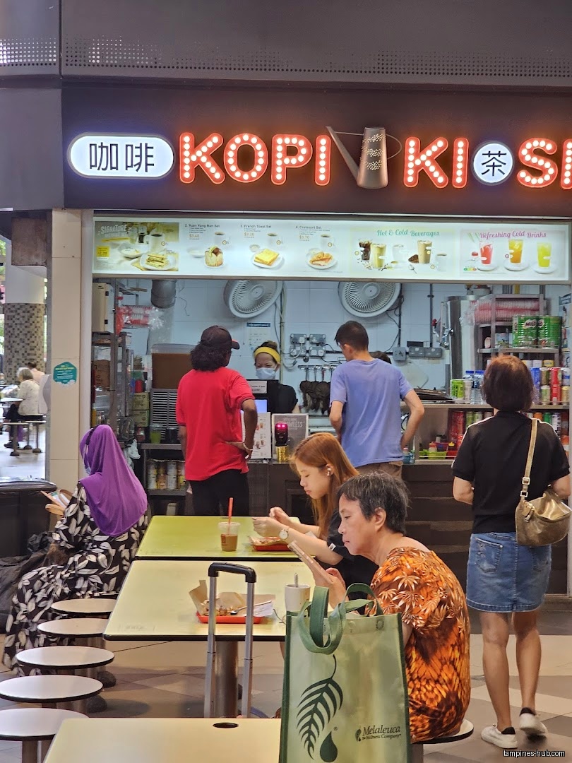 Kopi Kiosk shop front with customers and staff visible.