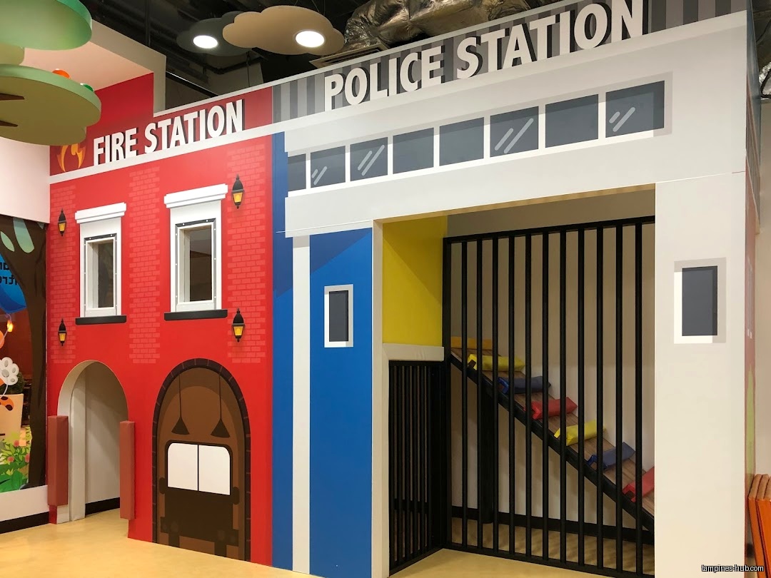 The image shows a play area with a fire station and police station.