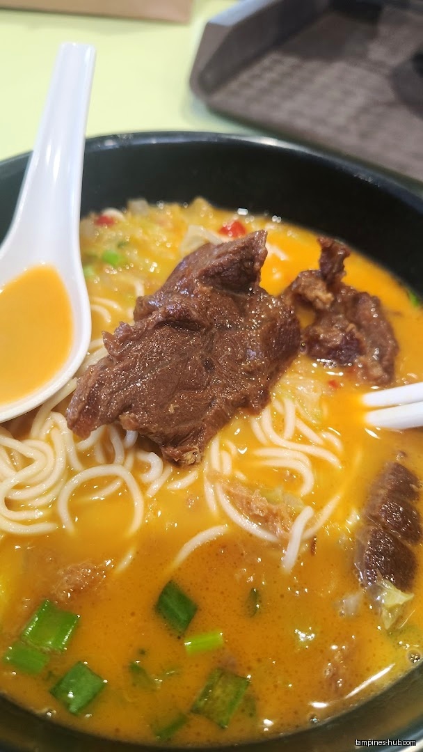 Close-up of a bowl of noodles with meat and broth.