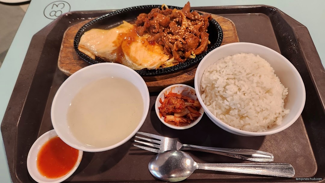 A tray with a meal including meat, rice, soup, and kimchi.
