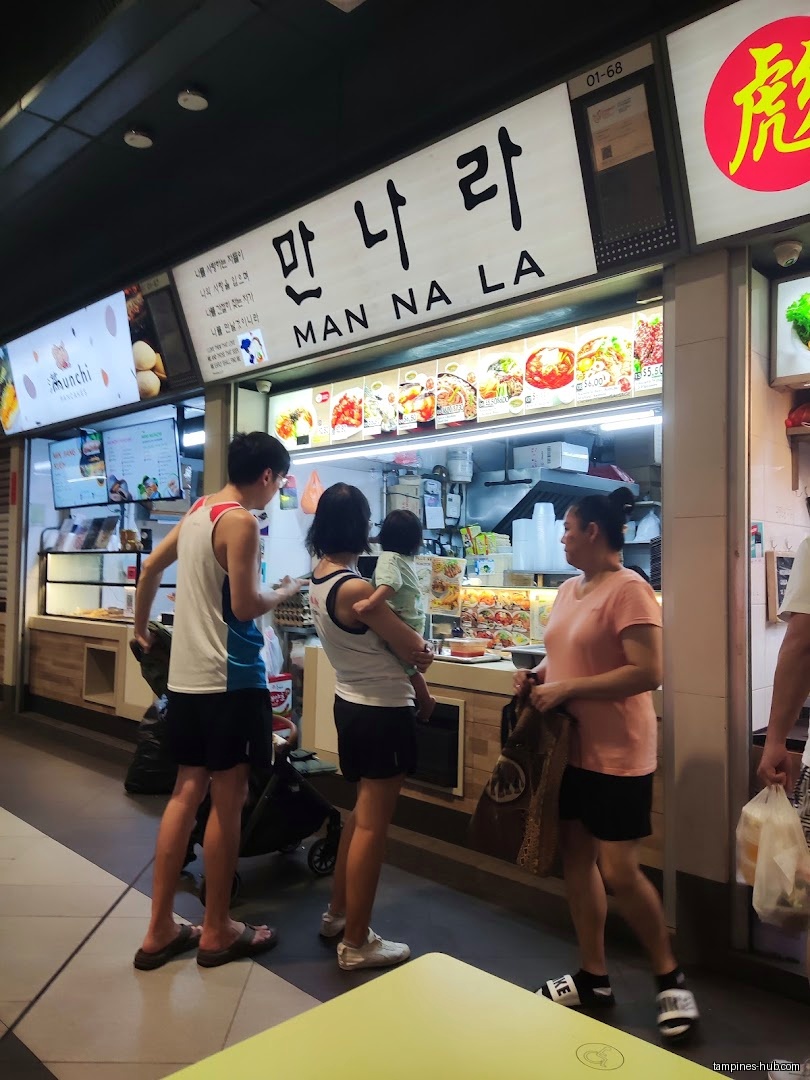 Customers are at the Man Na La shop front with menu displays.