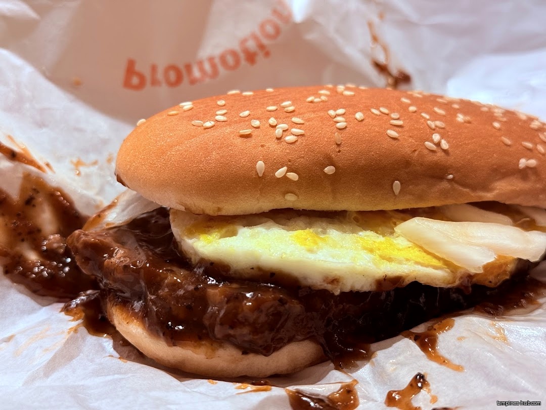 A close-up shot of a McDonald's burger with egg and sauce.