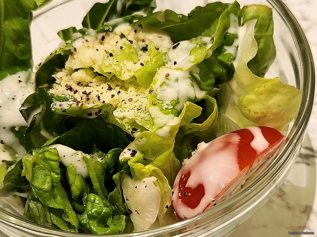 A close-up shot of a salad in a clear glass bowl.