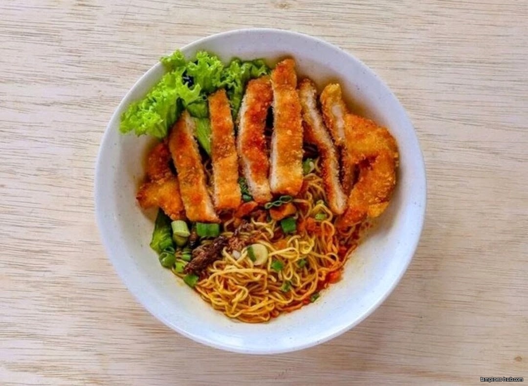 A bowl of noodles topped with fried pork cutlets and lettuce.