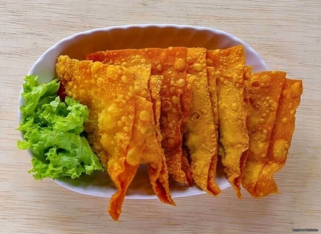 A plate of fried wontons with lettuce garnish is shown.