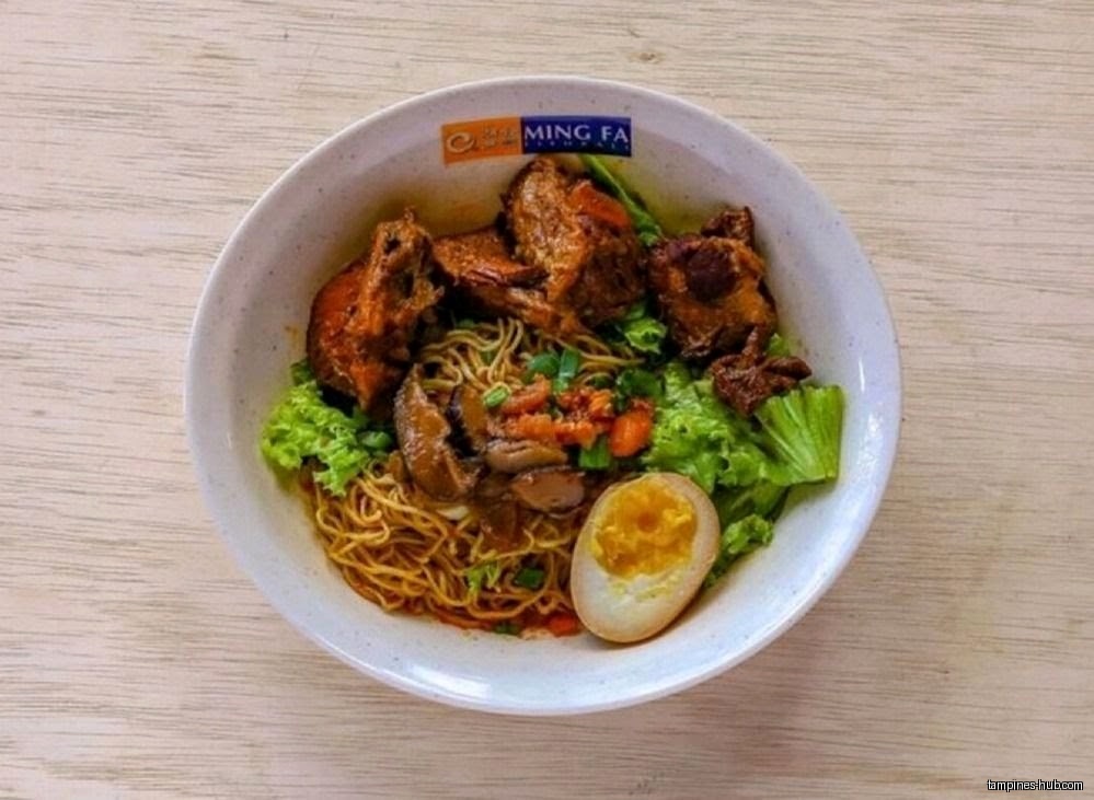 A bowl of Ming Fa noodles with chicken, egg, and vegetables.