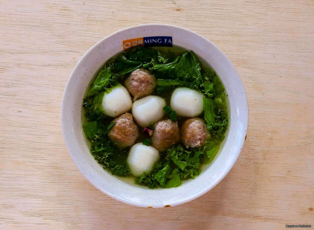 A bowl of Ming Fa fishball soup with greens and meatballs.