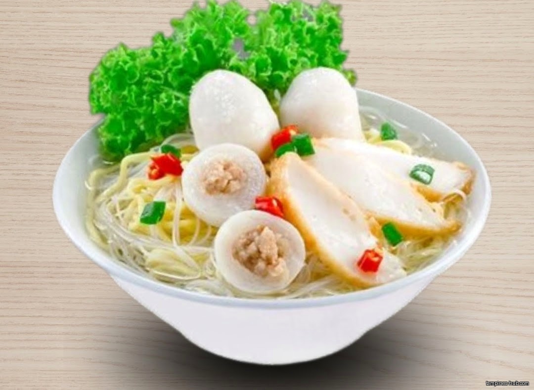 A bowl of fishball noodles with lettuce and chili garnish.