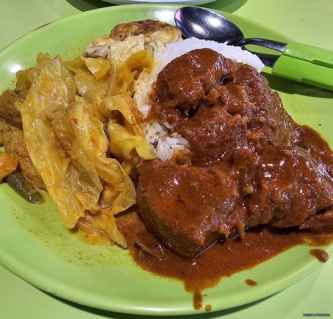 A plate of rice with rendang, vegetables, and an omelet is shown.