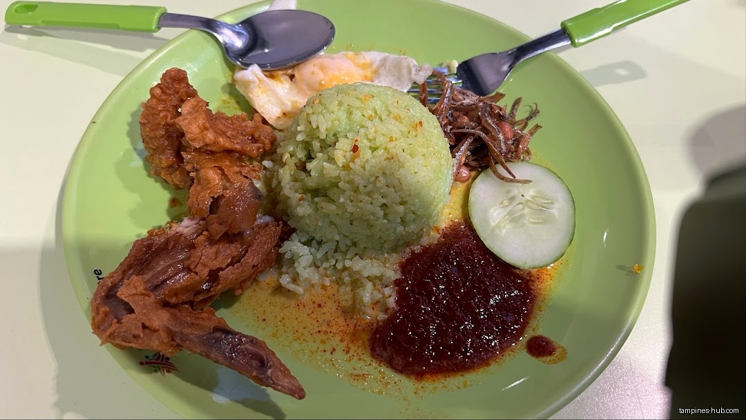 A plate of Nasi Lemak with fried chicken, egg, and sambal.
