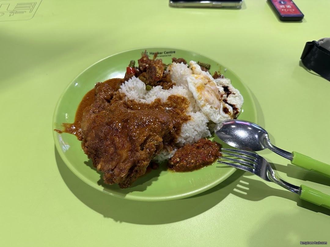 A plate of rice, rendang chicken, fried egg, and chili paste is shown.