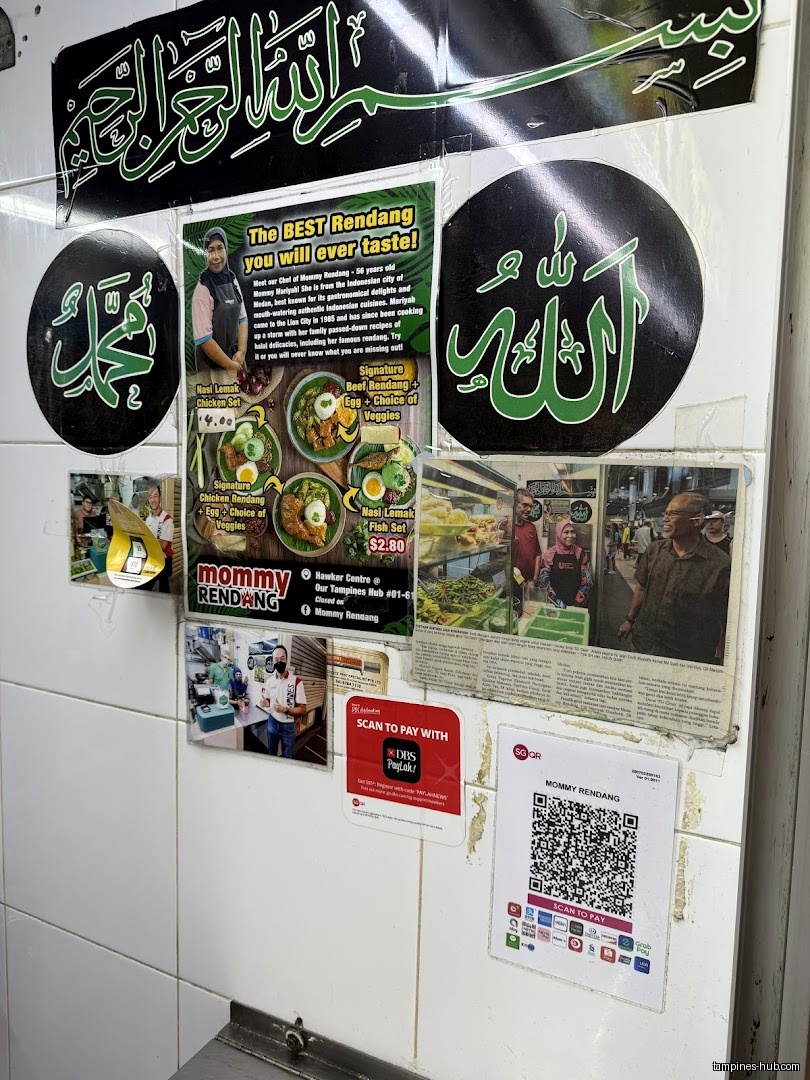 The image shows a wall with menus, photos, and payment QR codes for Mommy Rendang.