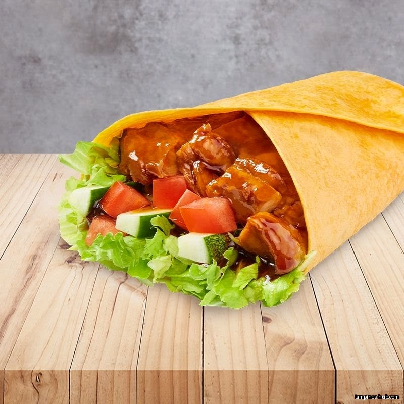 A wrap filled with lettuce, tomato, cucumber, and glazed chicken on wood.